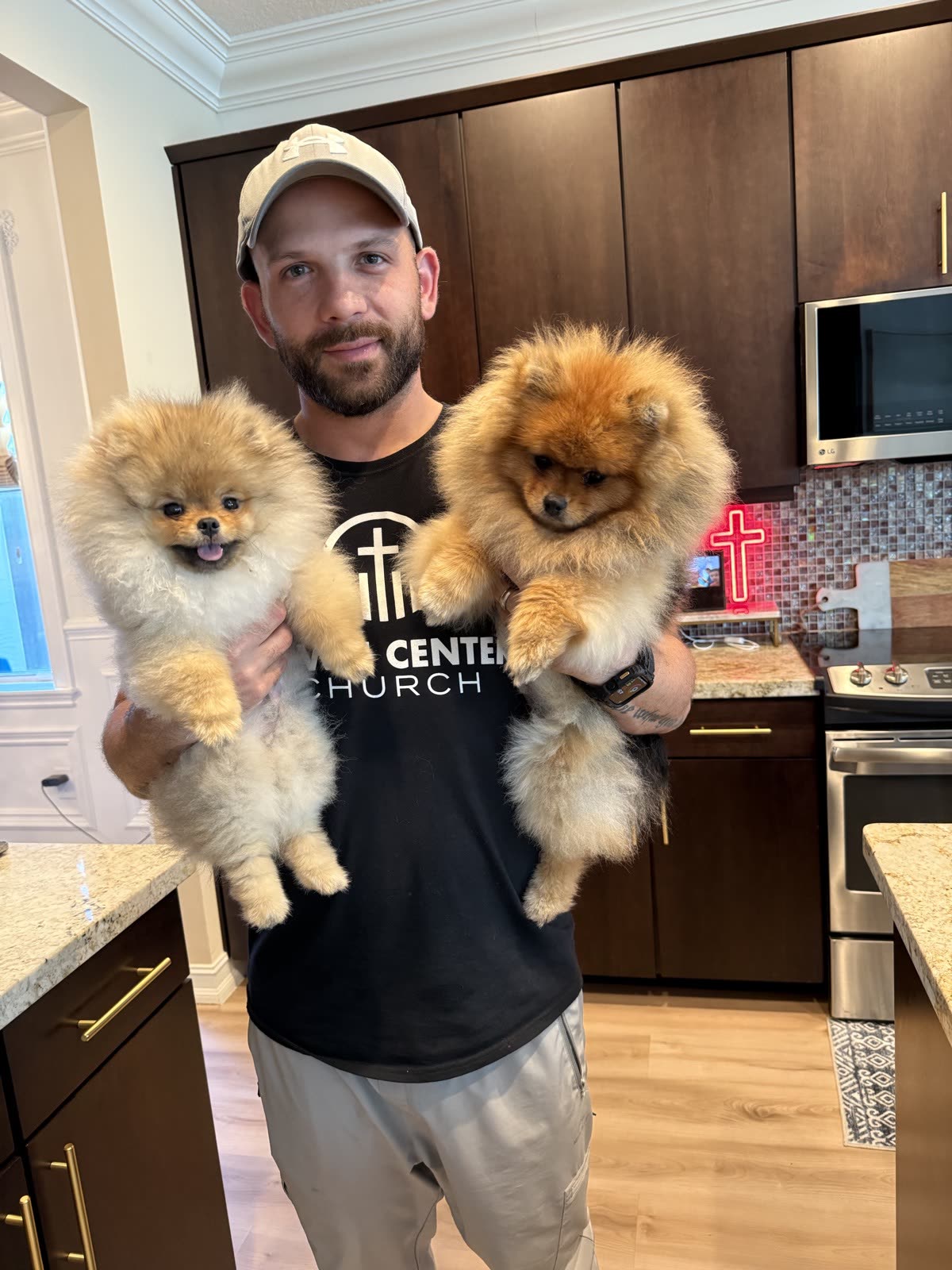 Matt holding Mocha and Mochi in the kitchen